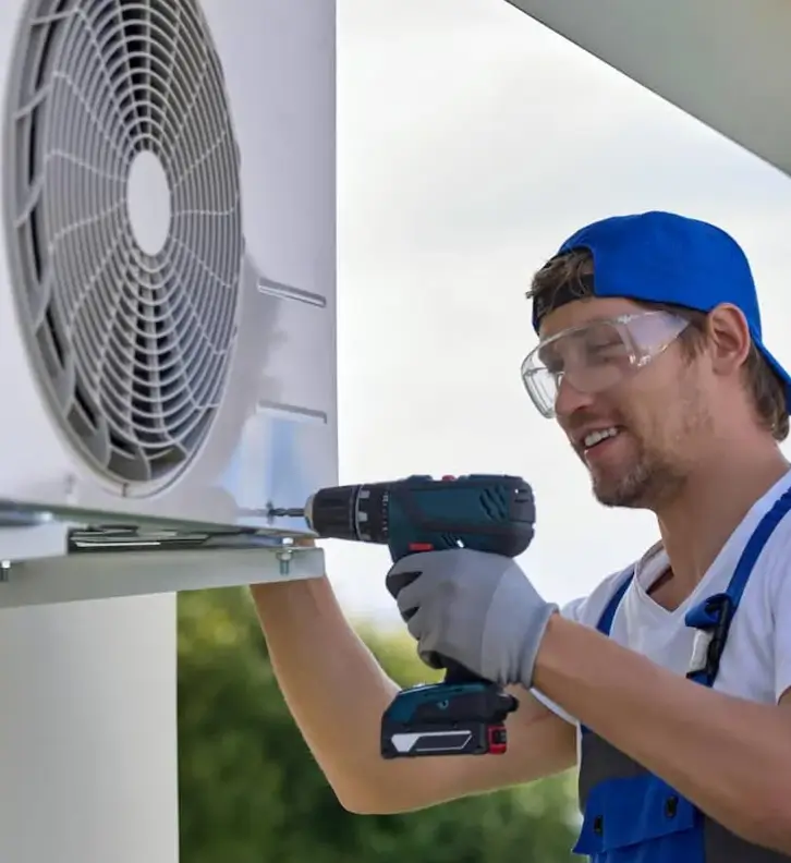 Técnico instalando equipamento de ar-condicionado com furadeira
